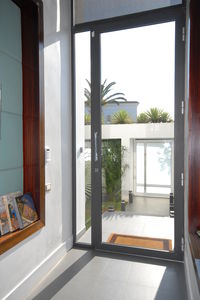puerta de entrada / abatible / de aluminio / con ventana lateral fija