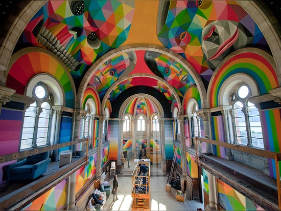 el okuda San Miguel pinta el mural colorido dentro del parque de interior del patín de la iglesia convertida