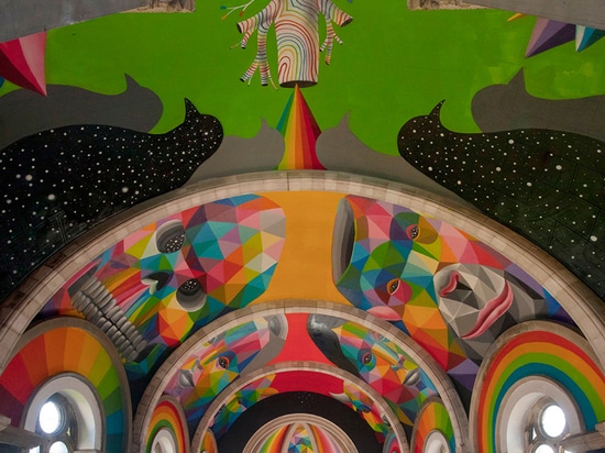 el okuda San Miguel pinta el mural colorido dentro del parque de interior del patín de la iglesia convertida