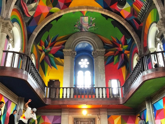 el okuda San Miguel pinta el mural colorido dentro del parque de interior del patín de la iglesia convertida