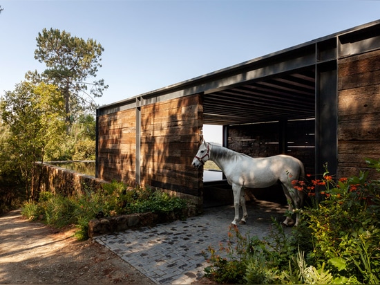 El establo construido de durmientes ferroviarios remata la casa del EL Mirador en México por cc Arquitectos