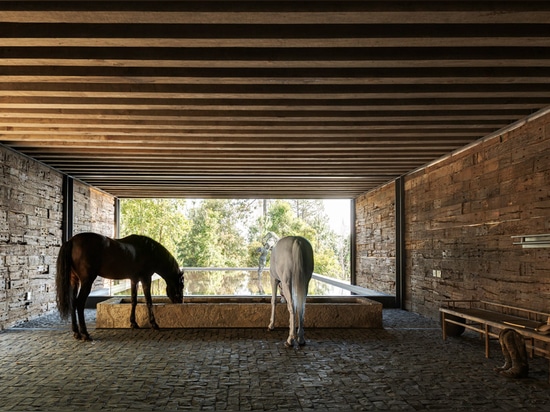 El establo construido de durmientes ferroviarios remata la casa del EL Mirador en México por cc Arquitectos