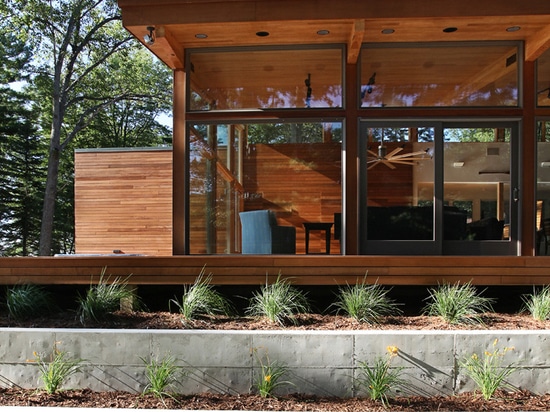 Esta casa de la orilla del lago del vidrio y de la madera fue diseñada con el espacio para dormir veinte personas