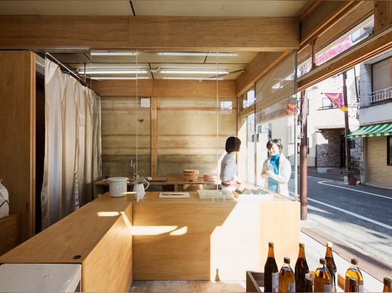 una ventana esmaltada separa la pequeña cocina del resto del volumen