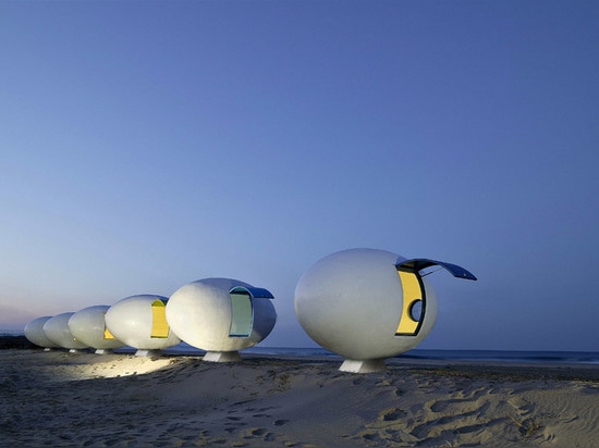 Chozas egg-shaped móviles de la playa instaladas a lo largo de una línea de la playa surcoreana