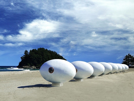 Chozas egg-shaped móviles de la playa instaladas a lo largo de una línea de la playa surcoreana