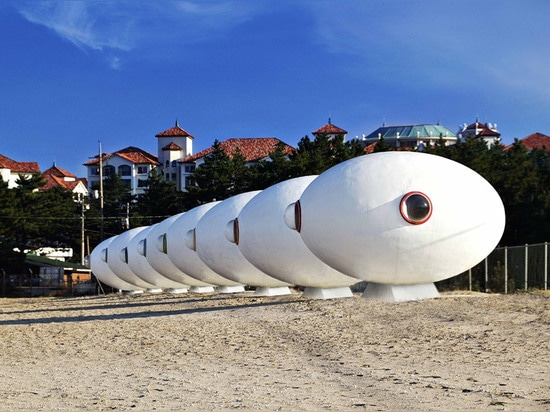 Chozas egg-shaped móviles de la playa instaladas a lo largo de una línea de la playa surcoreana