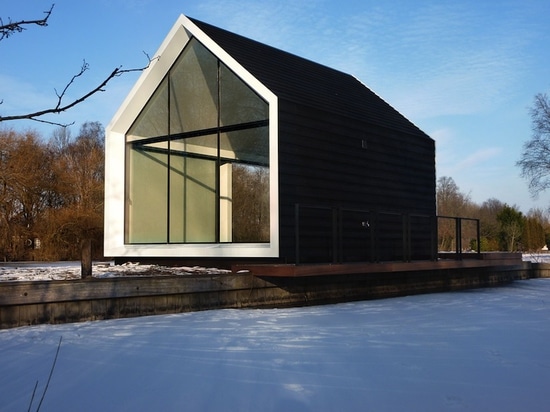 La cabina minúscula del vidrio y de la madera dobla listo abierto para mezclar adentro con el paisaje holandés