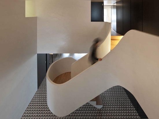 Correia/Ragazzi Arquitectos agregan curvar la escalera blanca a un apartamento portugués remodelado