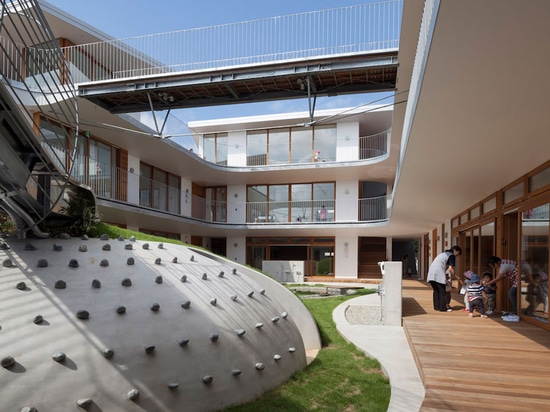 el taller de los arquitectos del aisaka organiza el cuarto de niños japonés alrededor de patio herboso