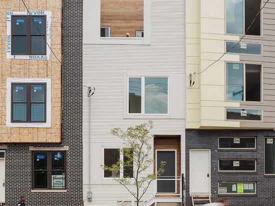 La escalera de la madera contrachapada extiende para arriba a través del centro de la casa urbana de Philadelphia por el AIA