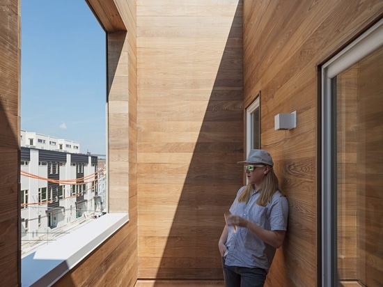 La escalera de la madera contrachapada extiende para arriba a través del centro de la casa urbana de Philadelphia por el AIA