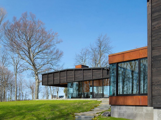 el chia del desai une tres estructuras compensadas para formar la casa carbonizada del lago de la madera en Michigan