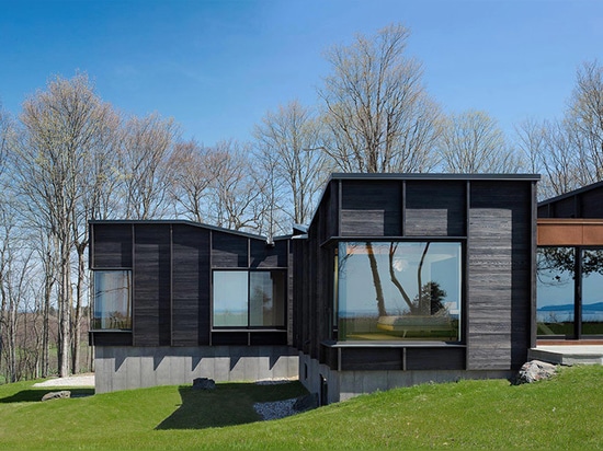 el chia del desai une tres estructuras compensadas para formar la casa carbonizada del lago de la madera en Michigan