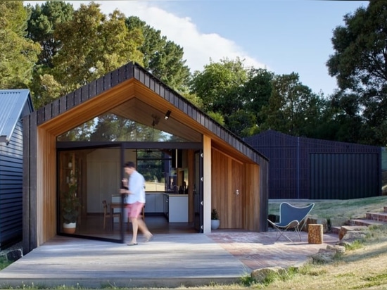 La extensión madera-revestida hermosa abraza el gran aire libre de Australia