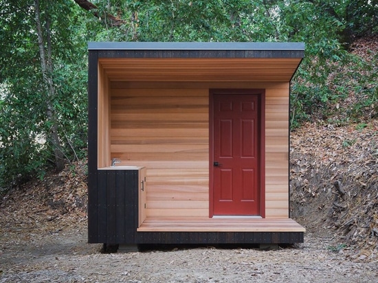 cabina de la madera con la red de las cubiertas suspendidas entre las secoyas de California