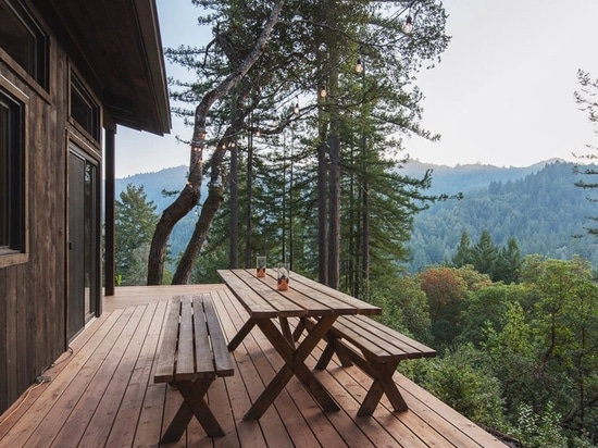 cabina de la madera con la red de las cubiertas suspendidas entre las secoyas de California