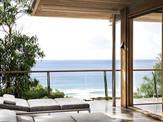 Casa de playa de madera y concreta que pasa por alto el océano