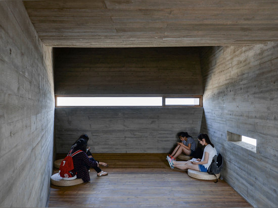 Cada espacio en el edificio tiene su propio acercamiento a encenderse; por ejemplo, en este sitio de la meditación, las pequeñas rajas permiten la luz adentro a través del día. Fotografía: Él compa...