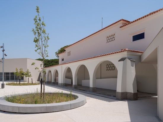 Los agujeros circulares conectan los patios de recreo en dos niveles de una escuela de Lisboa