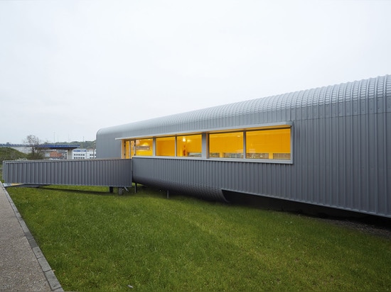 La forma oval del edificio permite que el agua de lluvia escurr el lado naturalmente y elimina la necesidad de canales. Lea más: ¿La cantina tubular de la escuela hecha a partir de 4 módulos prefab...