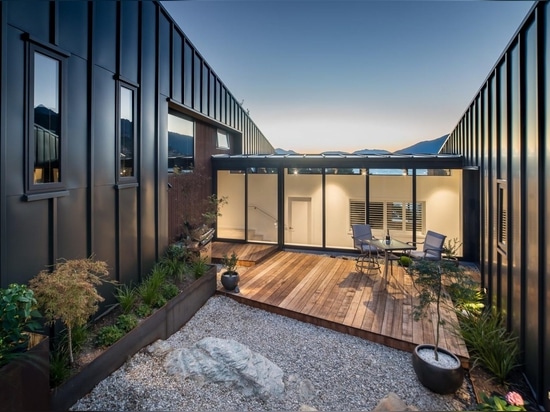 Esta casa en la ladera con revestimiento de metal negro fue diseñada para maximizar las vistas al lago