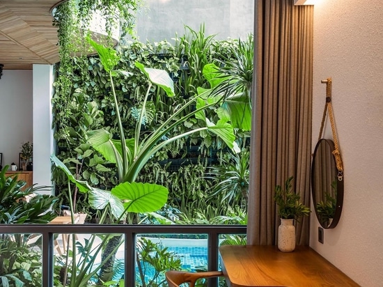 Los balcones ondulados con plantas colgantes son una característica de diseño en este edificio de apartamentos