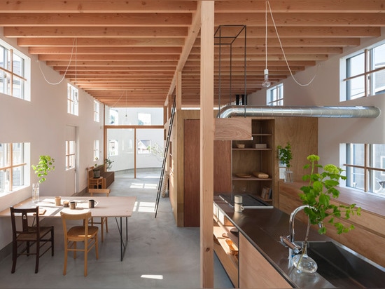 Una escalera aterriza en un escritorio dentro de la casa en Hikone de Tato Architects