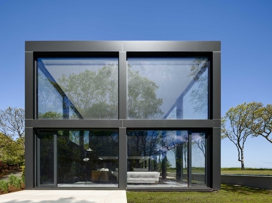 Una cuadrícula de grandes ventanas maximiza las vistas al agua en esta moderna casa