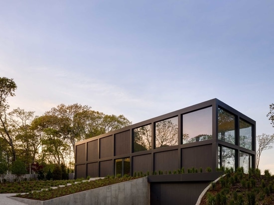 Una cuadrícula de grandes ventanas maximiza las vistas al agua en esta moderna casa