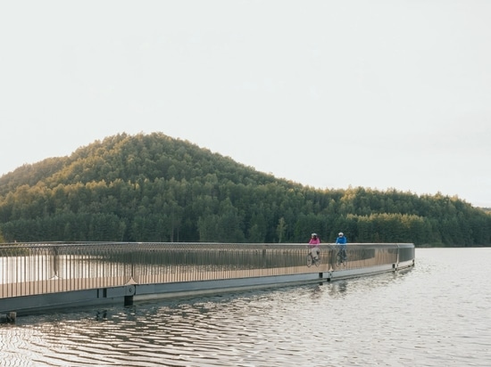 BuroLandschap tiende un puente para bicicletas sobre un lago en una antigua mina de carbón belga